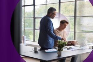 A tax professional analyzing federal tax return documents and financial charts with a colleague during tax season