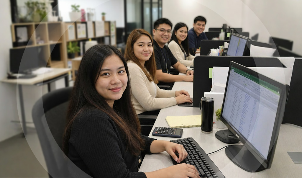 Five offshore accountants in the Philippines looking toward the camera from their workstations, delivering accounting services that support business growth.